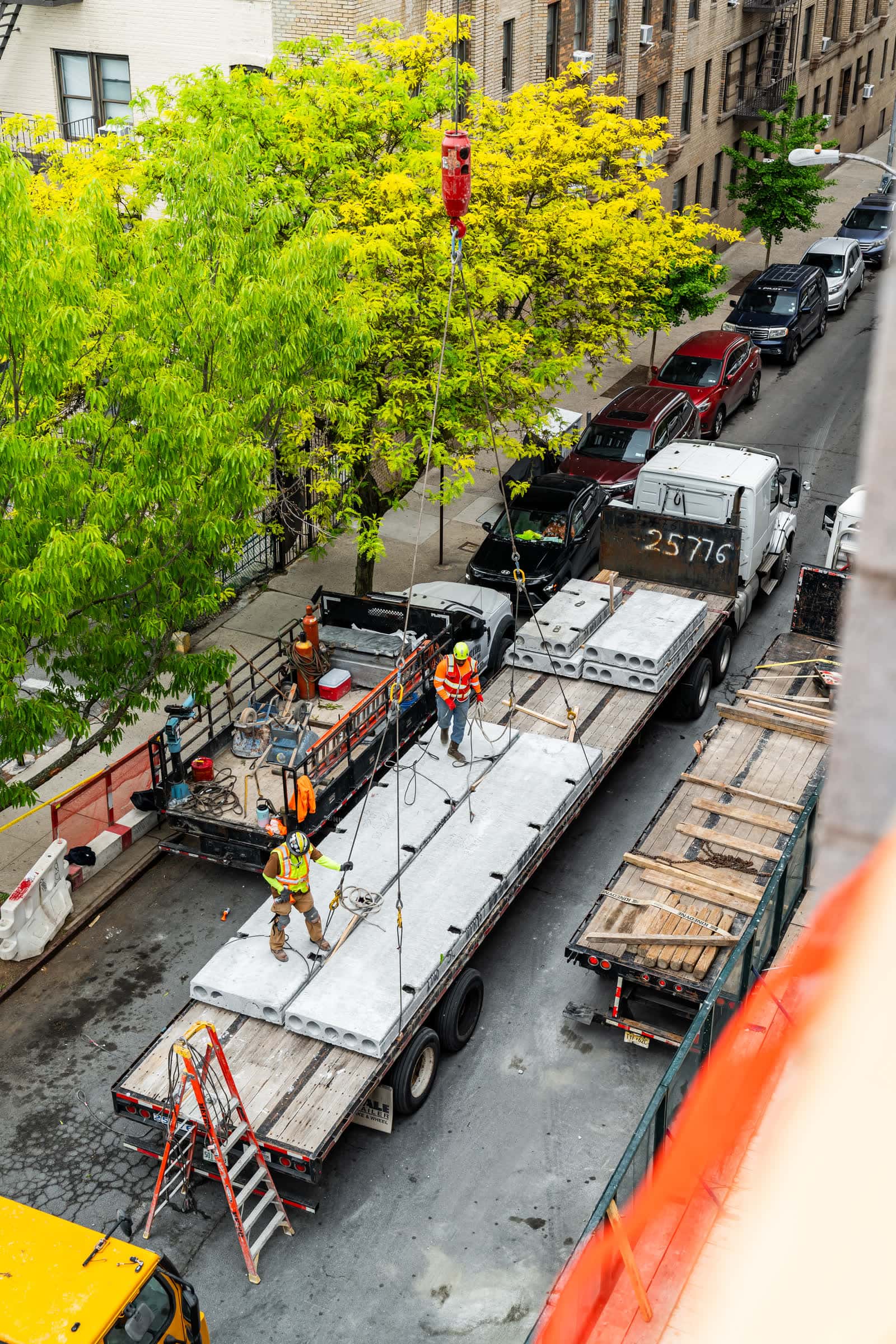 Overhead view of riggers working a plank flatbed on a city street