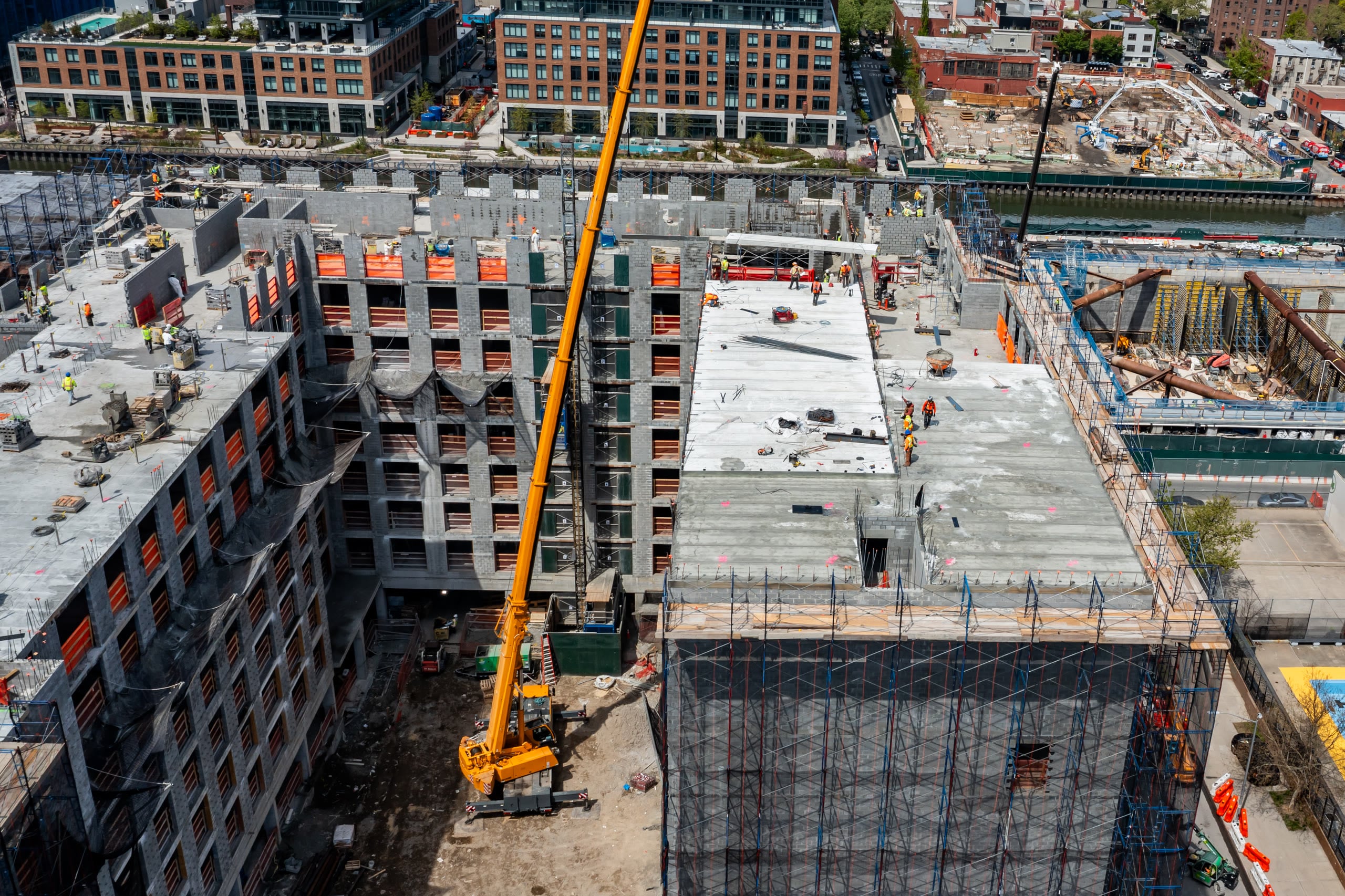 Aerial view of a crane boom over crews setting precast plank on a deck