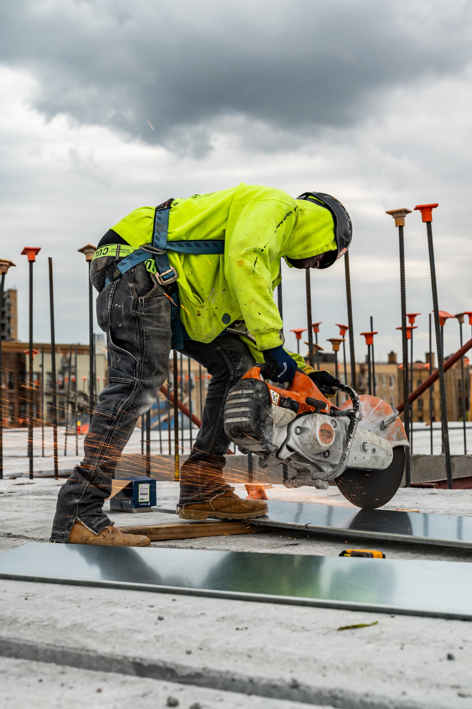 Worker cutting steel plate with a cut-off saw, sparks flying