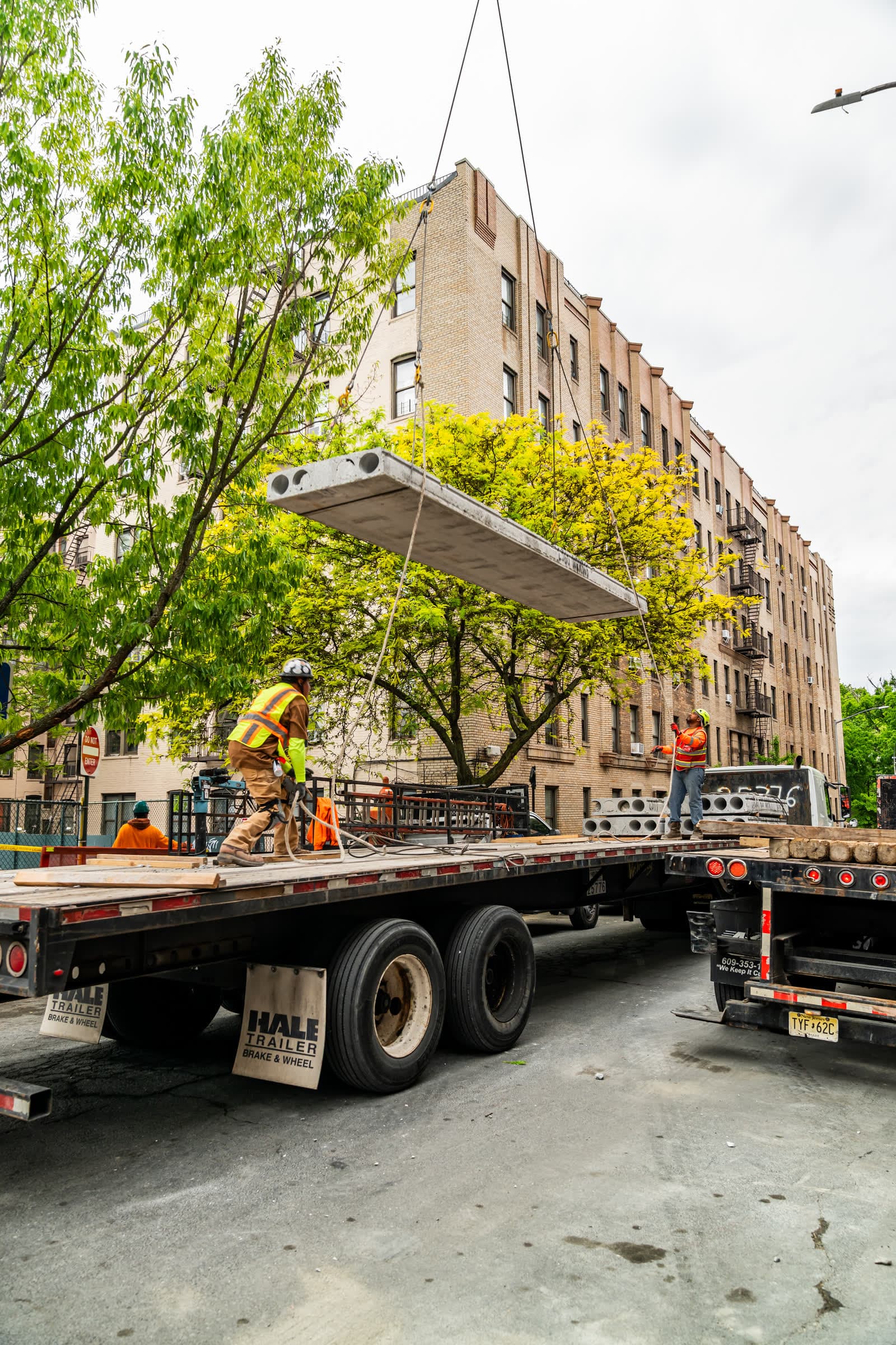 Hollow-core plank suspended from a crane over a New York street